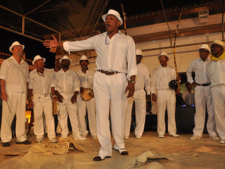 Veteran capoeira masters playing music and moving inside a roda