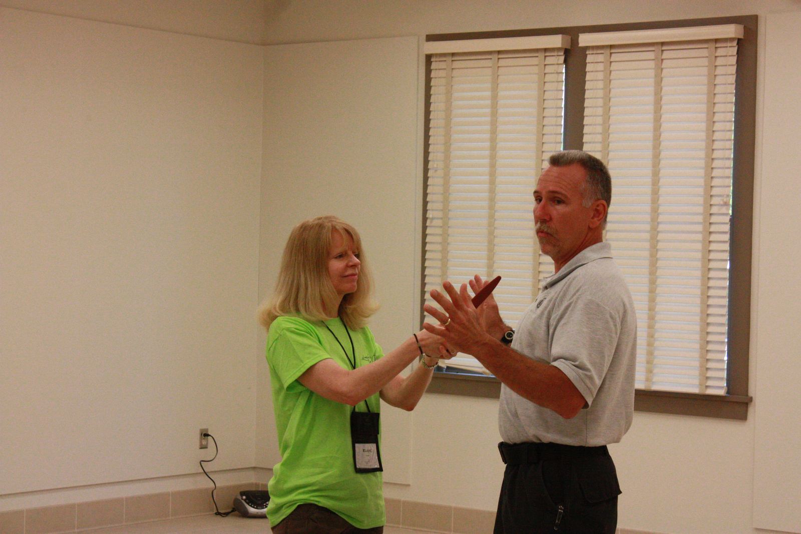 An instructor and a student practising a calm, open-hand stance in a community class